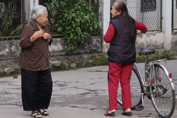 two Asian women talking on the street
