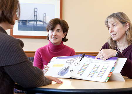 Sofia Diana Merajver, MD, PhD and Kara Miliron talk with a patient