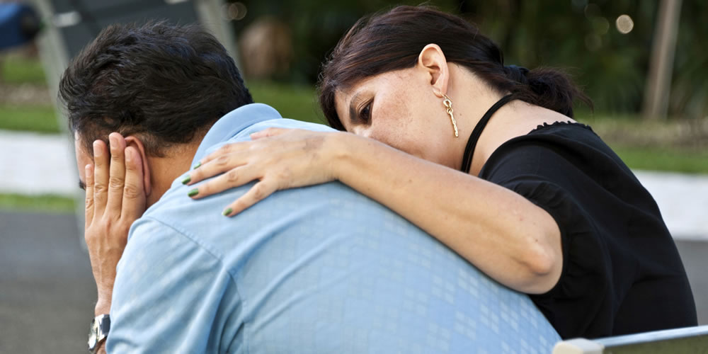 Woman talking to a man with her arm around him