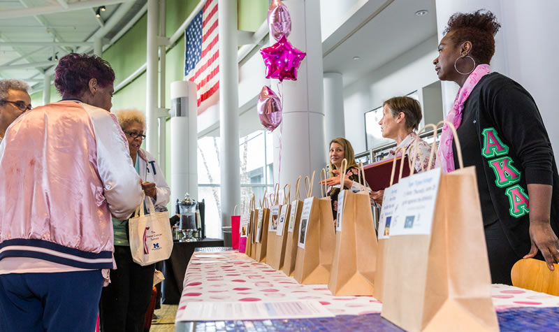 woman visits one of the many information booths at the Breast Cancer Summit