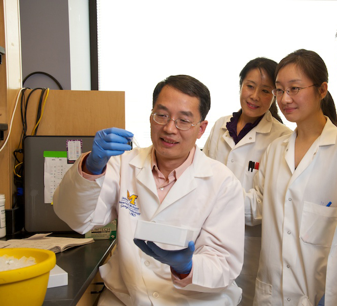 members of the research team examine the cell sample