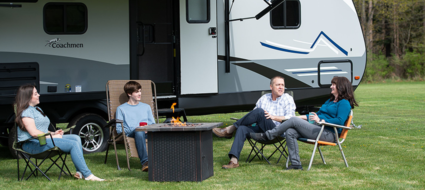 The Cauley family sitting outside their camper around a fire pit
