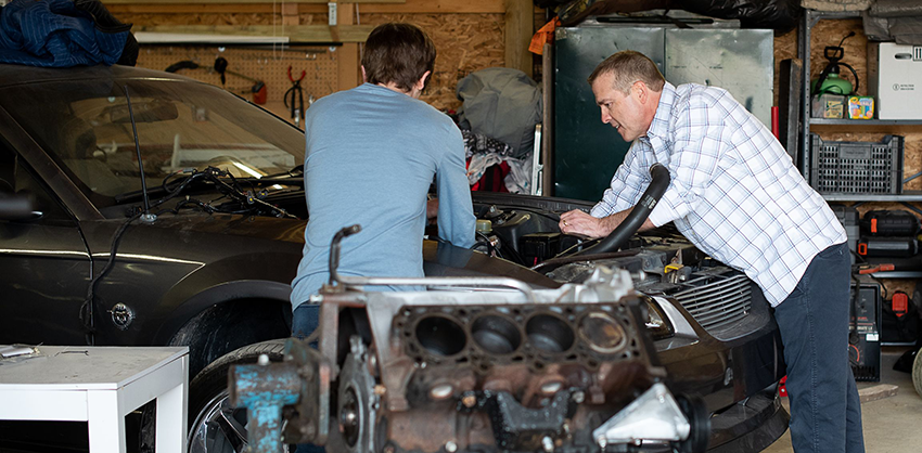 Chris Cauley and his son repair an old car