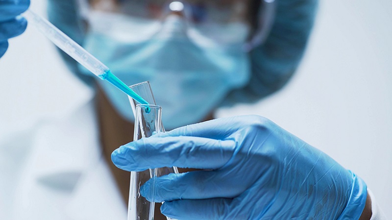 image of a researcher adding fluid to a test tube