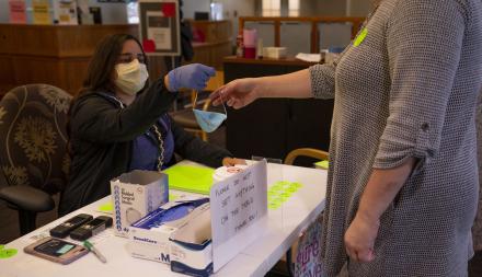 image of masked clerk checking in patient