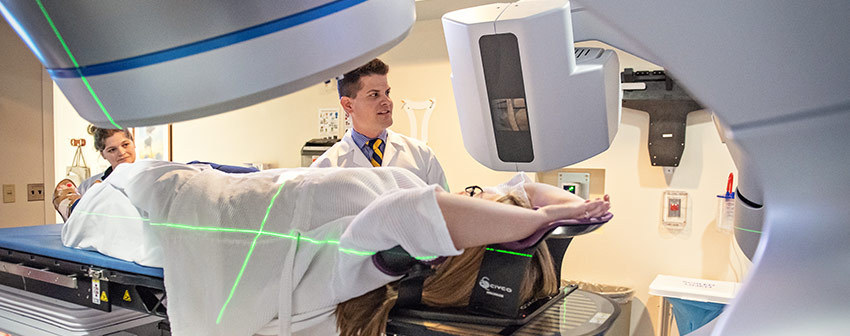 doctor and technician settle a female patient in an ultrasound machine