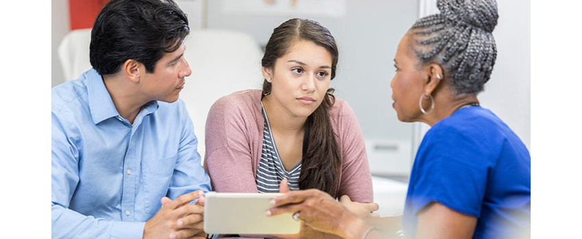 image of father and his teenaged daughter talk to a health care provider