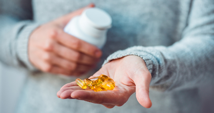 a person holding a handful of fish oil pills
