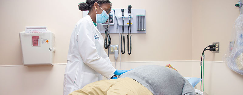 Black female doctor examines a male patient in the treatment room