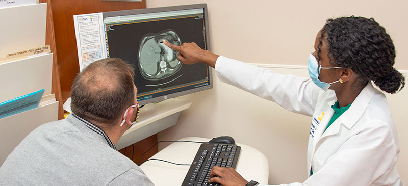 male patient is shown MRI results by Black female doctor