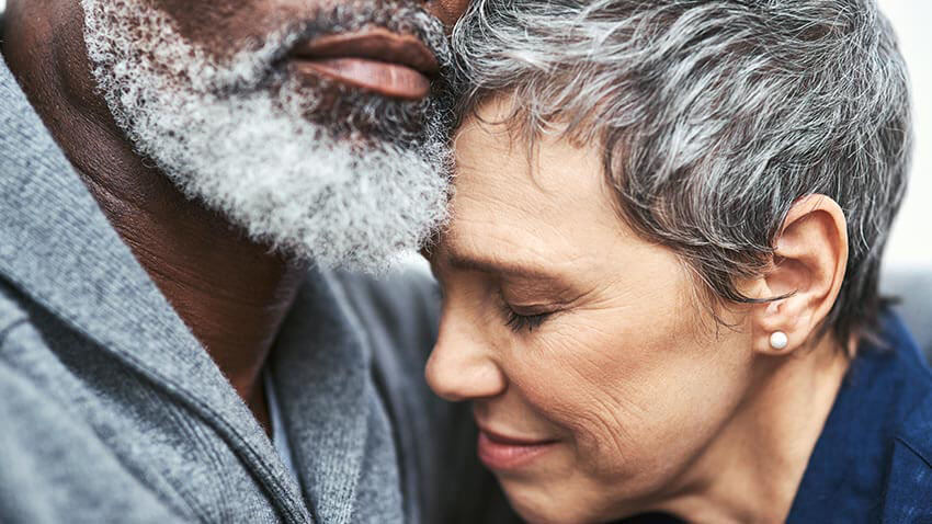 Black man and white woman hold hands in concern