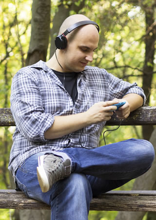 man sitting on a bench listening to music