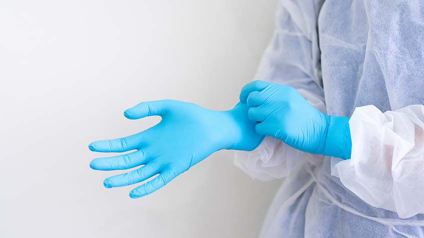 photo of person pulling on examination gloves