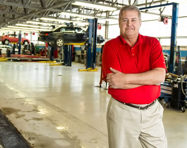 Stan Urban standing in an auto repair service area