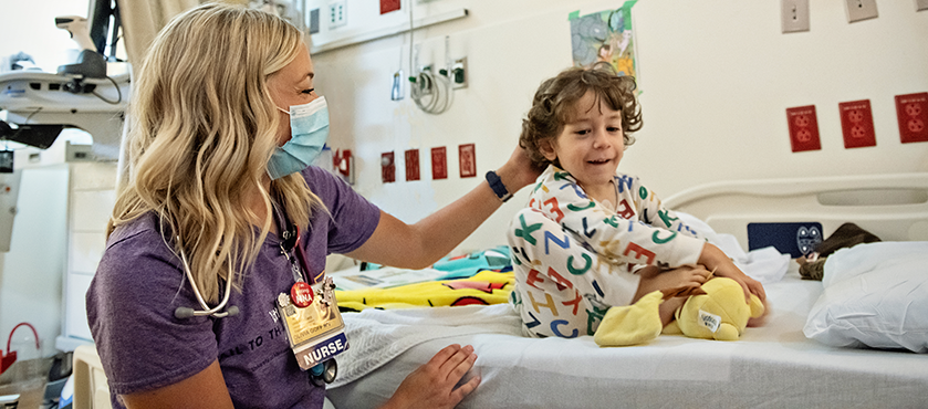 Olivia Goff working as a nurse, helping a little boy