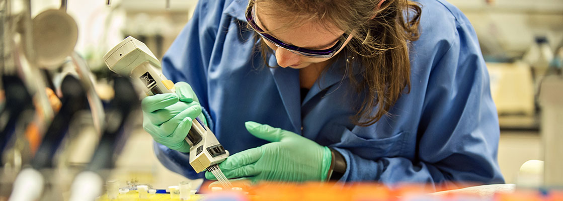 image of a lab technician putting specimens into beakers