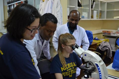 people around a microscope