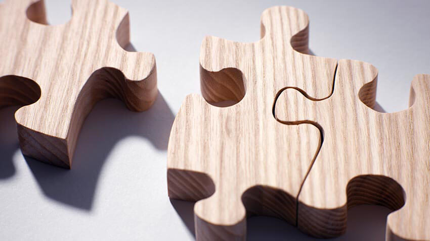 three wooden puzzle pieces fitting together