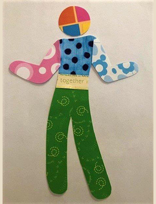 colorful stencil figure with green pants with yellow swirls and blue and black polka dot top