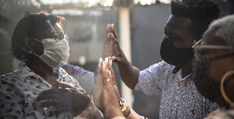 Black family visiting a quarantined mother through a window