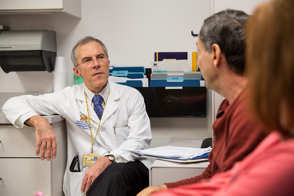 Dr. John Krauss talks to a patient in clinic