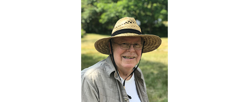 Bill Moldwin wearing a straw hat and smiling