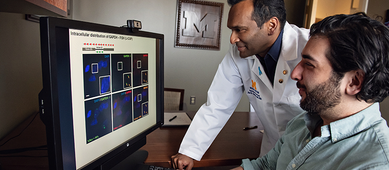 Arul Chinnaiyan, M.D., Ph.D. (left) and Yashar Niknafs, Ph.D. look at a computer monitor