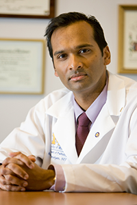 Arul Chinnaiyan, MD, PhD sits at his desk