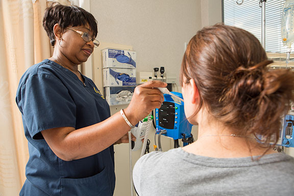 A medical assistant takes a patient's temperature