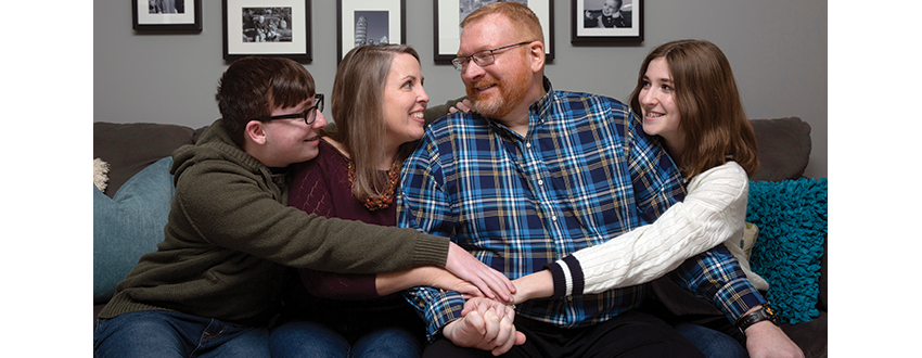 Keating family sitting on a couch in a big hug