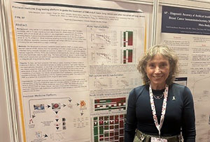 Dr. Sofia Merajver next to her poster at the Molecular Analysis for Precision Oncology Congress in London, 2024