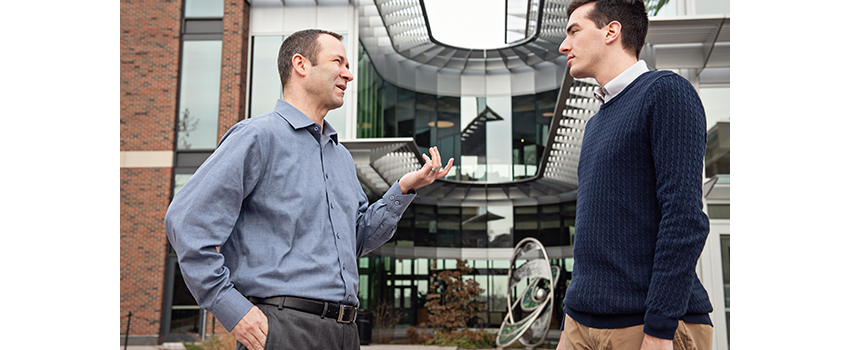 Christopher Friese, Ph.D., R.N. and colleague stand outside the NCRC building