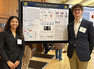 Sohair Holman and William Bieneman stand in front of their poster