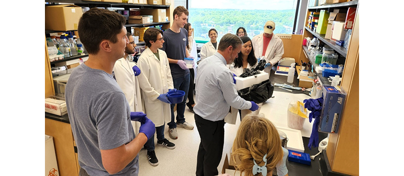 Male and female researchers in a lab gather to examine findings