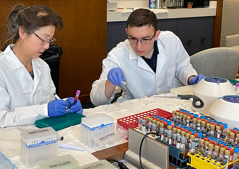 A woman and man work together sorting blood samples