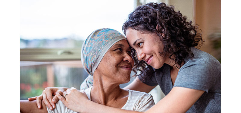 A woman wearing a head scarf embraces her daughter