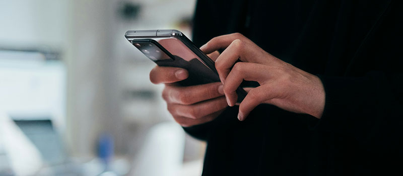 A pair of hands holds a cellular phone making a call
