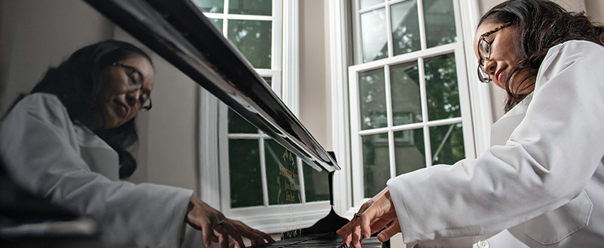 Aki Morikawa, MD,PhD sits at her piano, preparing to play