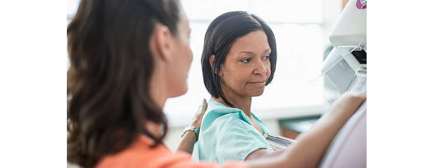 nurse helps Black woman with her mammogram