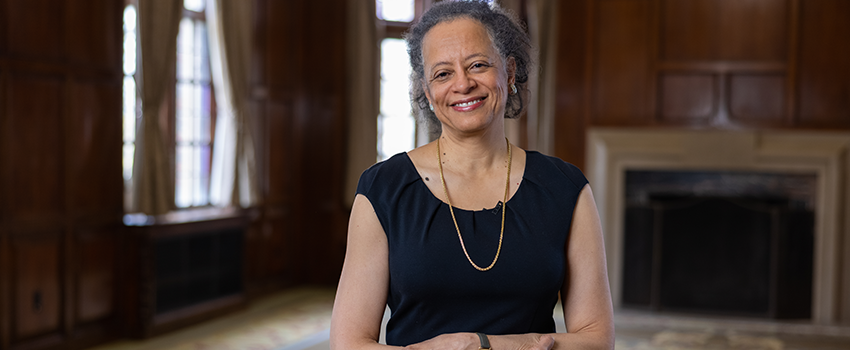 Lori Pierce MD stands in front of a fireplace in the Michigan League