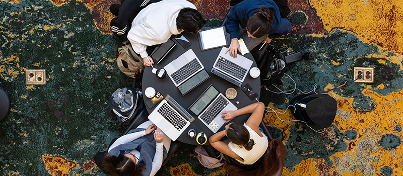Overhead view of people with their desks in a circle all on their computers