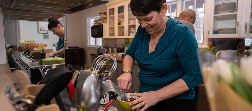 Tina Reuben in her kitchen standing at a counter chopping food