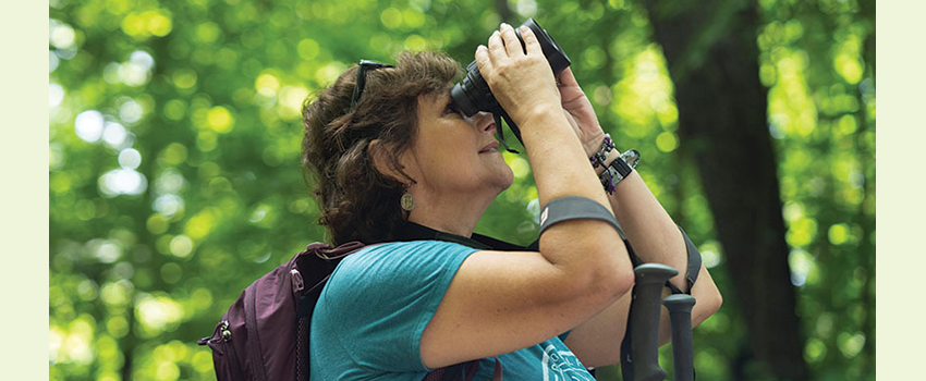 Woman in profile looking through binoculars