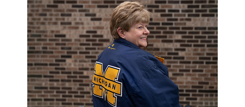 Woman looking over her shoulder wearing a michigan jacket