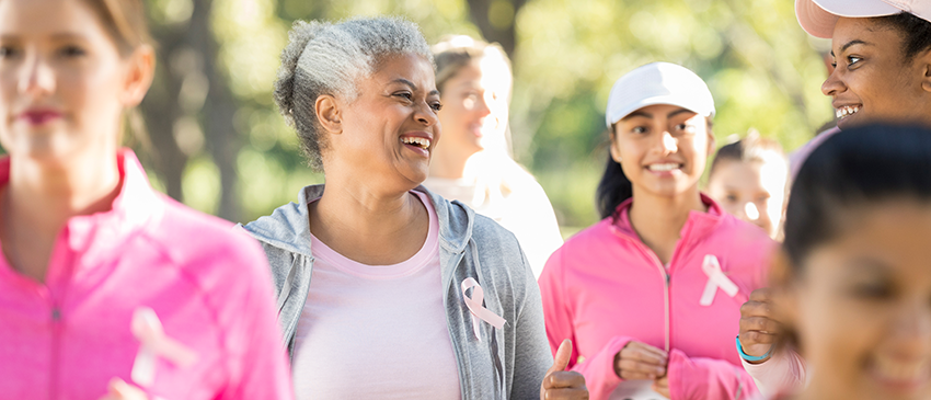 Women wearing pink t-shirts walking in the sunshine